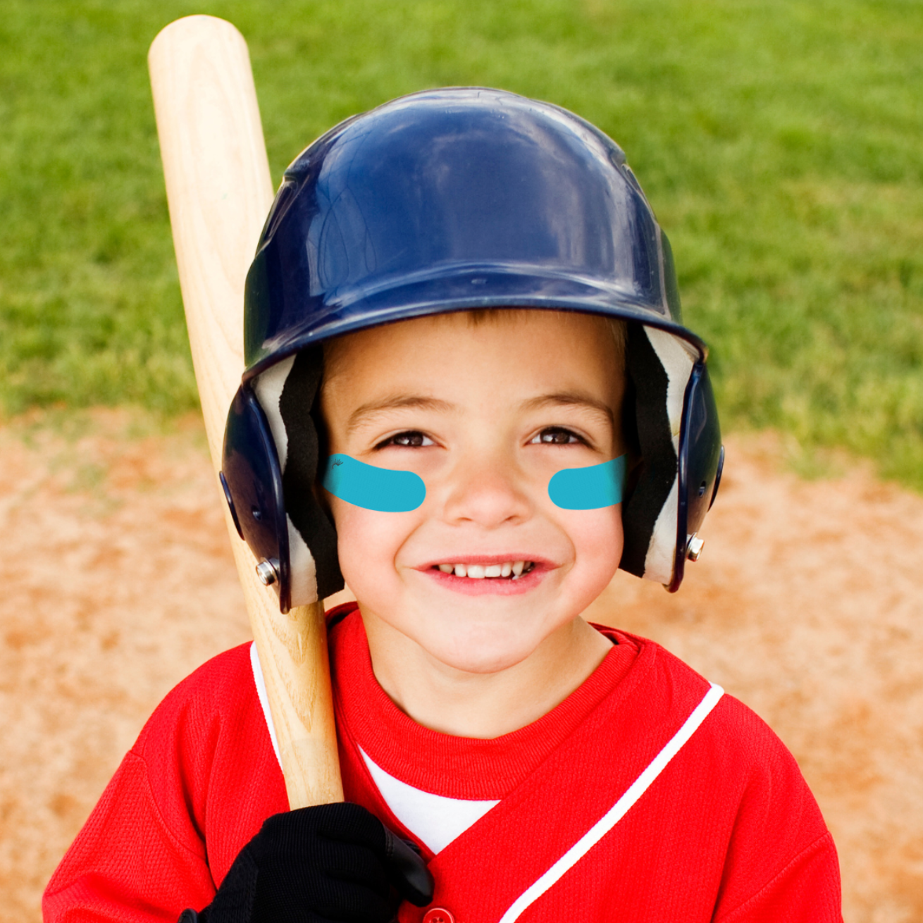 Child in a red baseball uniform with a bat and helmet on a baseball field