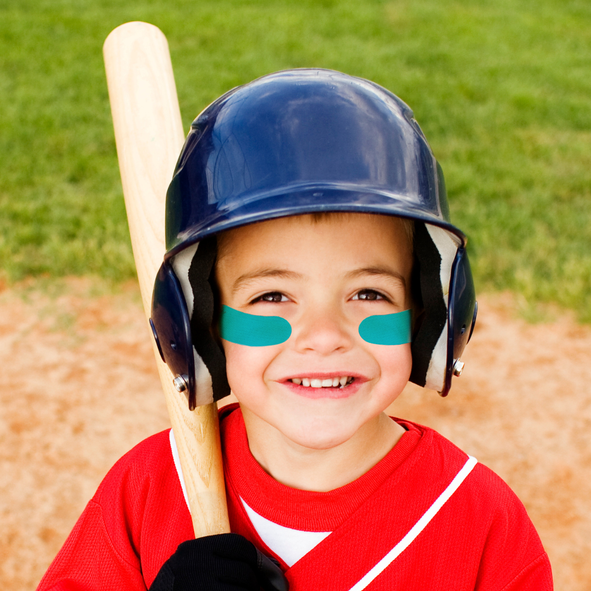 Child in a red baseball uniform with a bat and helmet on a baseball field